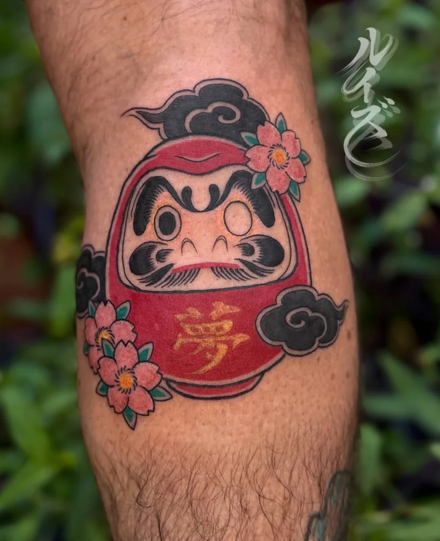 Red daruma tattoo framed by clouds and cherry blossoms by Luise (Lulu)