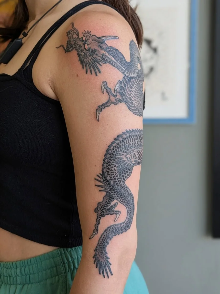 A detailed black dragon winding down the upper arm.