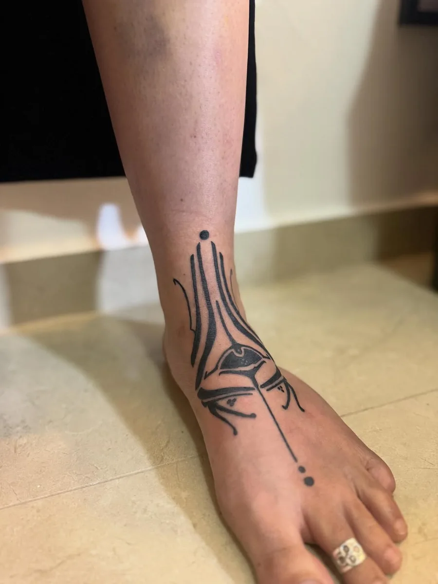 Ornamental tribal tattoo across the ankle and foot by Yonatan