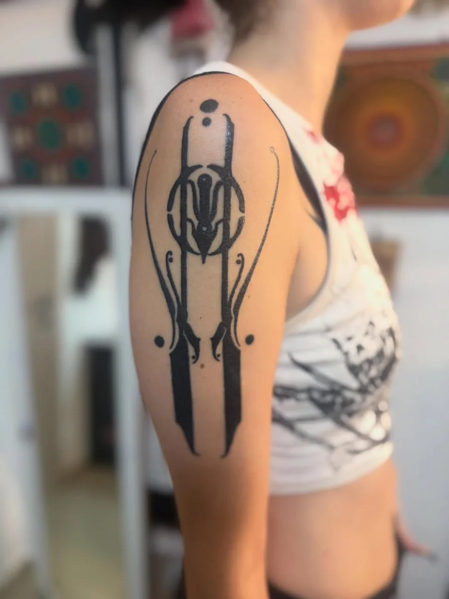 Vertical ornamental blackwork tattoo on the upper arm by Yonatan